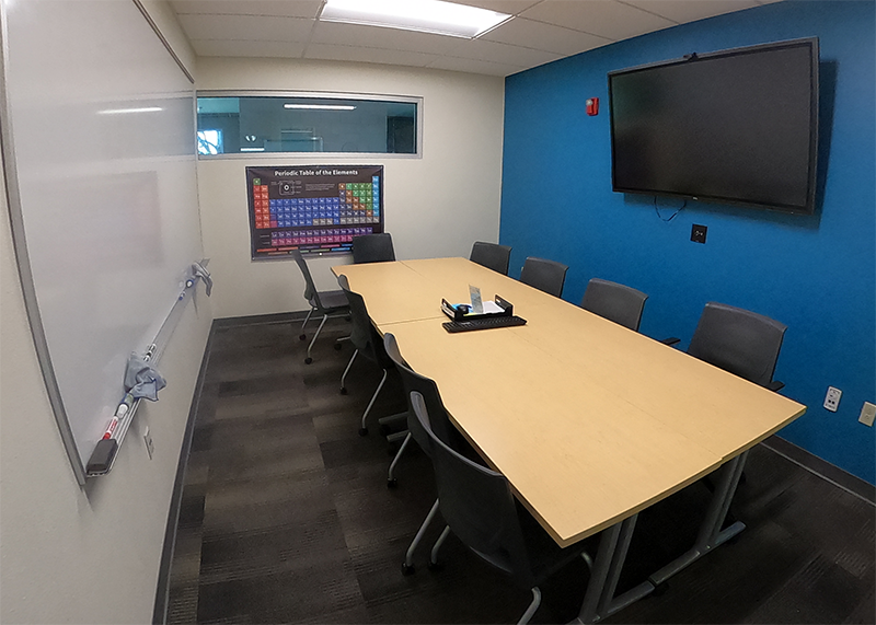 conference room with table, eight chairs, and monitor